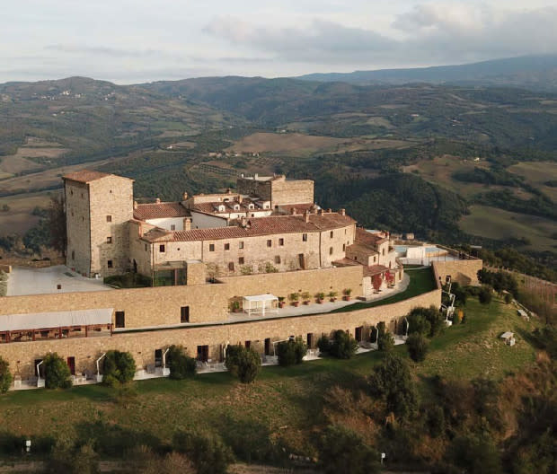 <p>Courtesy Image</p><p>Offering 360-degree views of the vineyards and ancient olive groves across the Val d’Orcia and just 30 minutes outside Siena, <a href="https://www.castellodivelona.it/" rel="nofollow noopener" target="_blank" data-ylk="slk:Castello di Velona;elm:context_link;itc:0;sec:content-canvas" class="link ">Castello di Velona</a> can trace its history back to the 11th century. A prime residence during the Renaissance, the castle fell into disrepair for hundreds of years, until 1997 when it was restored into a luxury <em>relais</em>, or inn.</p><p>All rooms offer beautiful views of the Val d'Orcia and the famed vineyards of Brunello of Montalcino, and have been designed in one of two styles: Monumental Rooms feature original Castle Tuscan style furnishing; UNESCO View Rooms have a more contemporary style with private patio sunset views.</p><p>You'll find a total of five restaurants here—three inside the resort and two outside. The hotel offers its own production of Brunello wine and extra virgin olive oil. The rustic Il Brunello in the historical part of the castle is run by executive chef Riccardo Bacciottini, formerly of NOMA in Copenhagen, and offers five-course and seven-course tasting menus. Settimo Senso Restaurant serves traditional Tuscan fare in a modern setting. There's also a poolside restaurant.</p><p>The OLISPA features five treatment rooms with a view of the Val d’Orcia, a special cabin dedicated to couple treatments, and a Wet Area with two Turkish baths, a panoramic sauna, ice fountain, and showers that stimulate senses through aromatherapy and chromotherapy. There’s also a gym outside located under the veranda. </p><p>Closest airport: Umbria International Airport.</p><p>[<span>booking.com</span>]</p>
