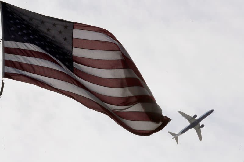 FILE PHOTO: A Delta Airlines flight takes off past a U.S. flag in Boston