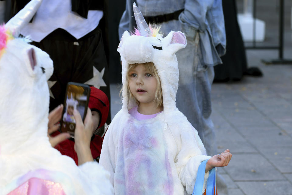 Ava Nicolary, 4, has her photo taken during a Halloween celebration at Denver's Union Station on Thursday, Oct. 28, 2021. Though the pandemic remains a concern, top health officials are largely giving outside activities like trick-or-treating the thumbs up. (AP Photo/Thomas Peipert)