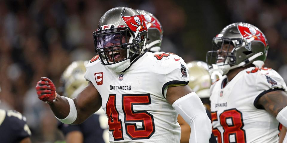 Devin White pounds his chest and smiles as Buccaneers players celebrate.