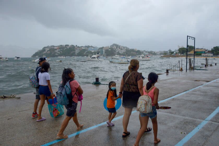 People walk along the coast in Acapulco, Guerrero State, Mexico, on August 16, 2023, following the passage of Tropical Storm Hilary. (Photo by FRANCISCO ROBLES / AFP) (Photo by FRANCISCO ROBLES/AFP via Getty Images)