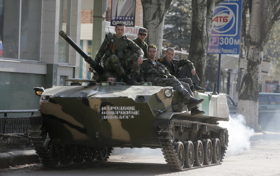 A combat vehicle with pro-Russian gunman on top runs through downtown Slovyansk, Eastern Ukraine, Friday, April 18, 2014. Ukraine is hoping to placate Russia and calm hostilities with its neighbor even as the U.S. prepares a new round of sanctions to punish Moscow for what it regards as fomenting unrest. (AP Photo/Efrem Lukatsky)