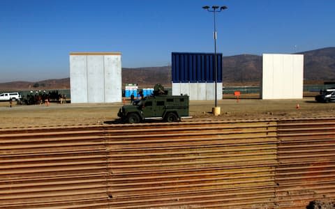 Border patrol authorities visit the site where several prototypes for U.S. President Trump's border wall with Mexico have been built, in this picture taken from the Mexican side of the border, in Tijuana - Credit: Reuters