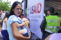 <p>A Venezuelan woman holds a girl at a health post for migrants in Cucuta, along Colombia’s border with Venezuela, Monday, July 16, 2018. (Photo: Christine Armario/AP) </p>