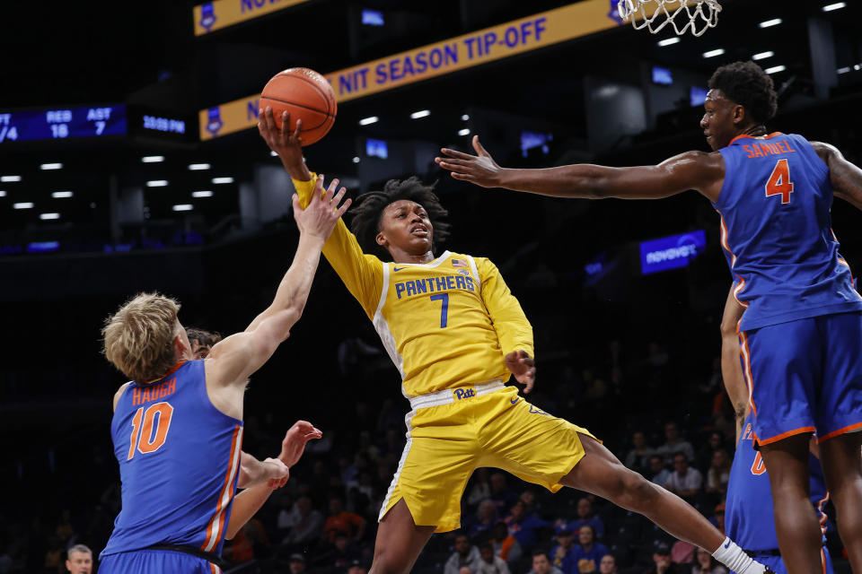 Pittsburgh guard Carlton Carrington (7) drives to the basket against Florida forward Tyrese Samuel (4) and forward Thomas Haugh (10) during the first half of an NCAA college basketball game in the NIT Season Tip-Off at Barclay's center, Wednesday, Nov. 22, 2023, in New York. (AP Photo/Eduardo Munoz Alvarez)