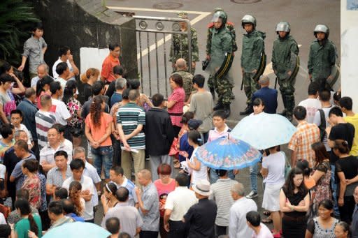 Chinese paramilitary police (top) guard the government offices Shifang in China's Sichuan province on July 4, a day after authorities bowed to violent protests and cancelled plans to build a controversial metals factory. The protests in Shifang city highlighted and fuelled concerns around China over the impacts of rampant economic development on the environment