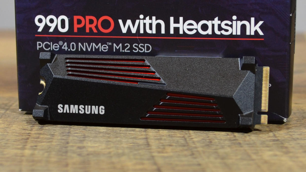  A Samsung 990 Pro on a wooden table in front of its retail packaging. 