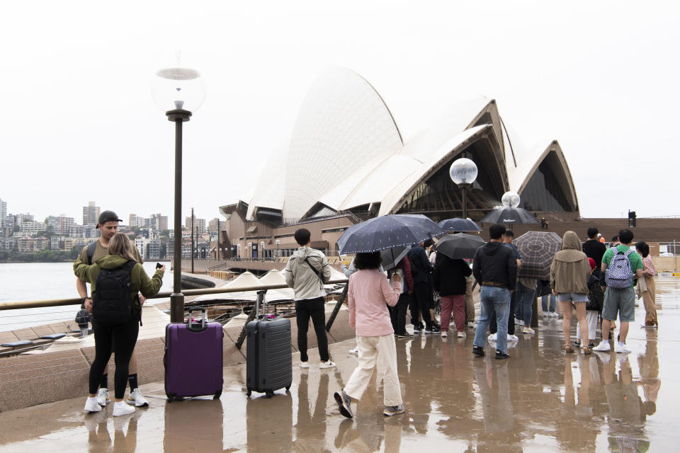 Crowd of people with umbrella's at Sydney's Opera House as it rains, with a cyclone also predicted to hit the west coast. 