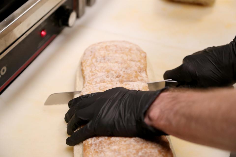 Chef Drew Wrenn slices a loaf of ciabatta bread at Starland Cafe.
