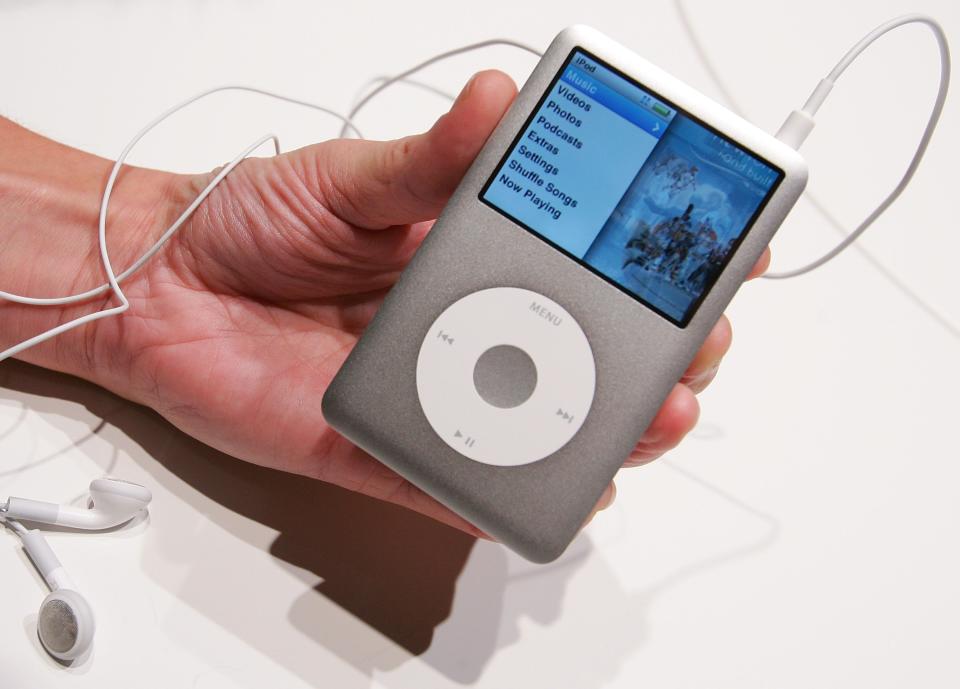 A hand holding a Classic silver iPod