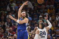 Golden State Warriors guard Klay Thompson, left, passes the ball over Memphis Grizzlies forward Dillon Brooks (24) and guard Ja Morant during Game 1 of a second-round NBA basketball playoff series Sunday, May 1, 2022, in Memphis, Tenn. (AP Photo/Brandon Dill)