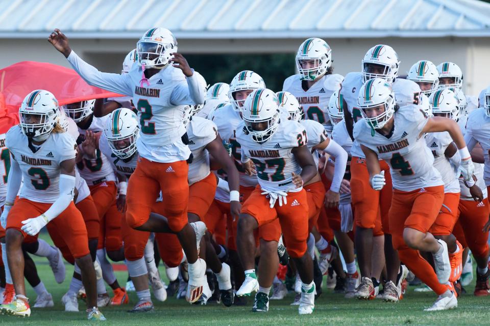 Mandarin players race onto the field for the season opener at Fletcher.