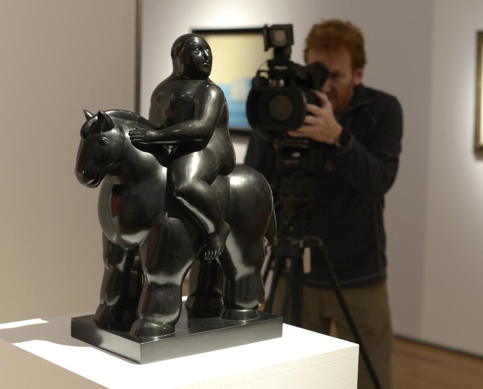 Un camarógrafo filma una escultura titulada 