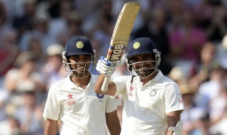 India's Mohammed Shami (R) waves his bat after reaching his half century as he stands with team-mate Bhuvneshwar Kumar during the first cricket test match against England at Trent Bridge cricket ground in Nottingham, England July 10, 2014. REUTERS/Philip Brown