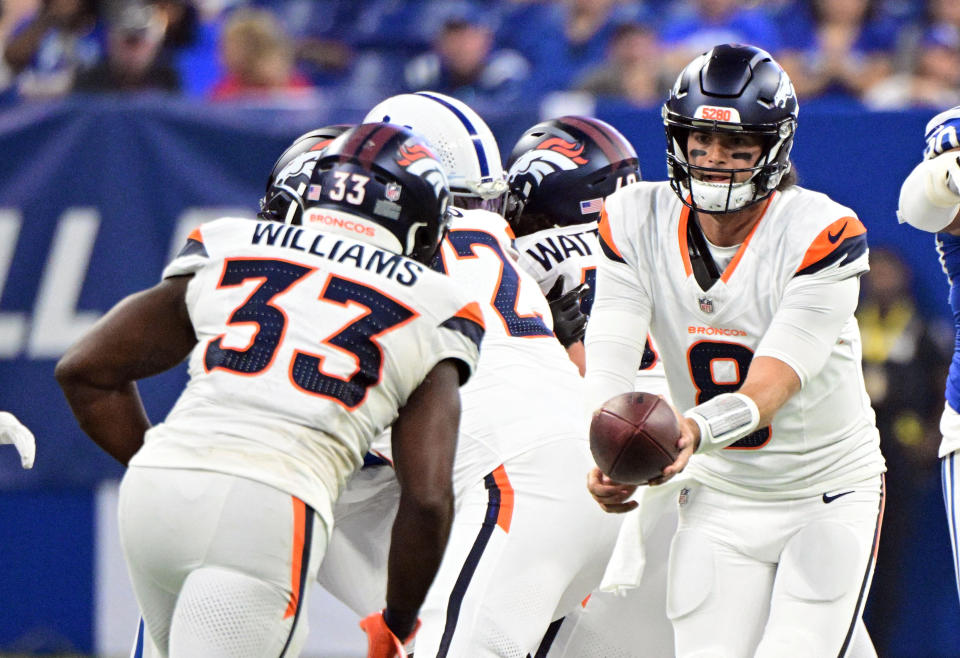 Aug 11, 2024; Indianapolis, Indiana, USA;  Denver Broncos quarterback Jarrett Stidham (8) hands the ball off to Denver Broncos running back Javonte Williams (33) during the first quarter at Lucas Oil Stadium. Mandatory Credit: Marc Lebryk-USA TODAY Sports