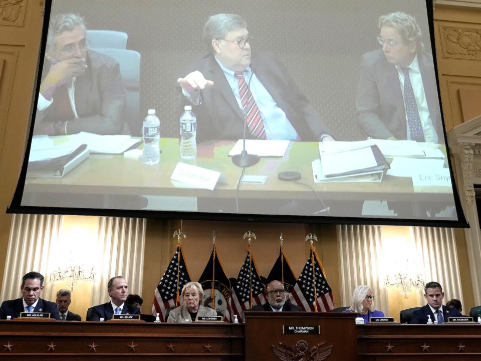 A video image of former Attorney General Bill Barr appears on a screen above the House select committee investigating the January 6 insurrection.