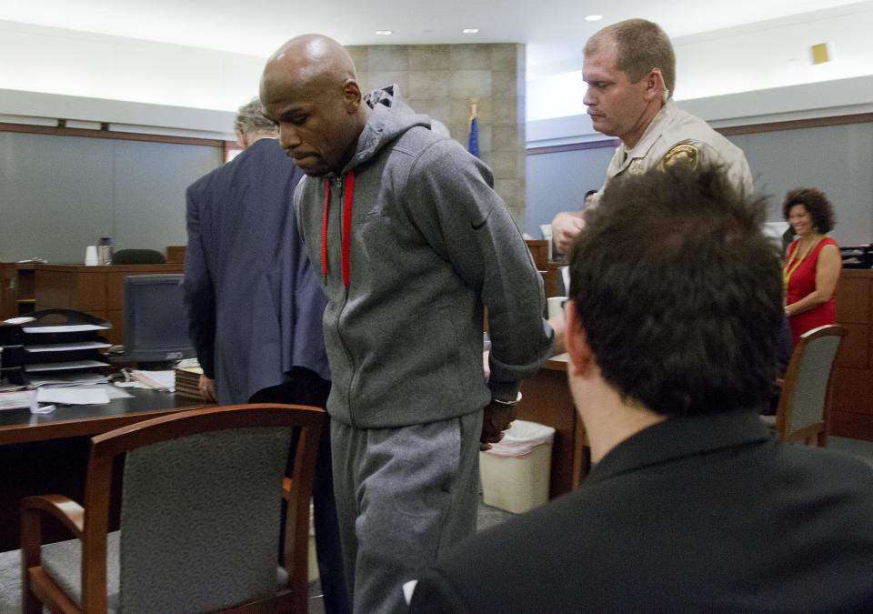 Floyd Mayweather Jr., left, is led away by court marshall Ron Johnson, Friday, June 1, 2012, in Las Vegas, to begin a 90-day jail term for attacking his ex-girlfriend in September 2010 while two of their children watched. The undefeated five-division champion surrendered Friday before the judge who sentenced him in December, and then allowed him to remain free long enough to headline a May 5 fight. (AP Photo/Julie Jacobson)