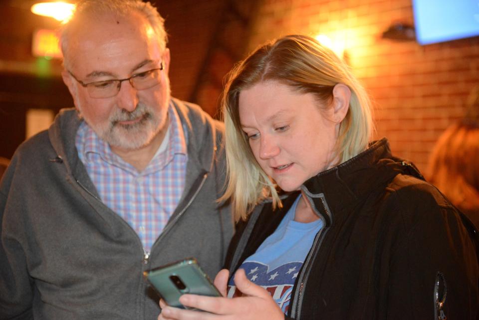 Stephanie Zader looks over election results Tuesday evening with Mansfield council president David Falquette.