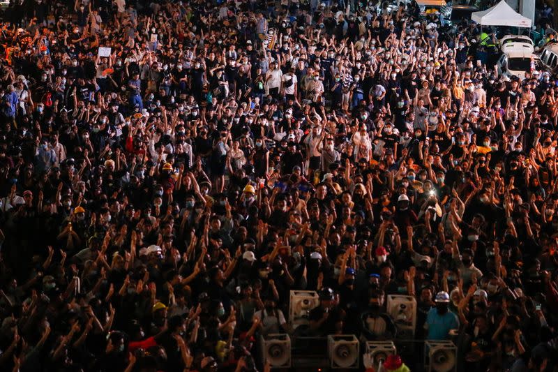 Demonstrators show the three-fingered salute during a rally in Bangkok