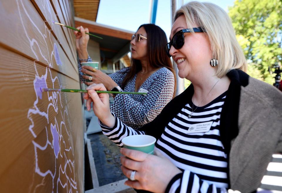 Hogle Zoo board members Tiffany Sorcic, right, and Amanda McKell help paint a western giant hyssop that is part of Matt Willey’s bee and pollinator mural on the new Norma W. Matheson Education Animal Center inside the future Aline W. Skaggs Wild Utah exhibit at the Hogle Zoo in Salt Lake City on Tuesday. Willey is an artist and founder of The Good of the Hive initiative.