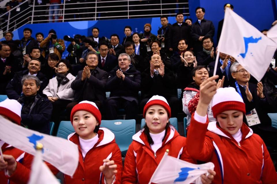 South Korea President Moon Jae-in and North Korean leader Kim Jong Un’s sister Kim Yo Jong (right) sit behind North Korean cheerleaders as the unified Korea women’s hockey team plays at the Winter Olympics. (Getty)