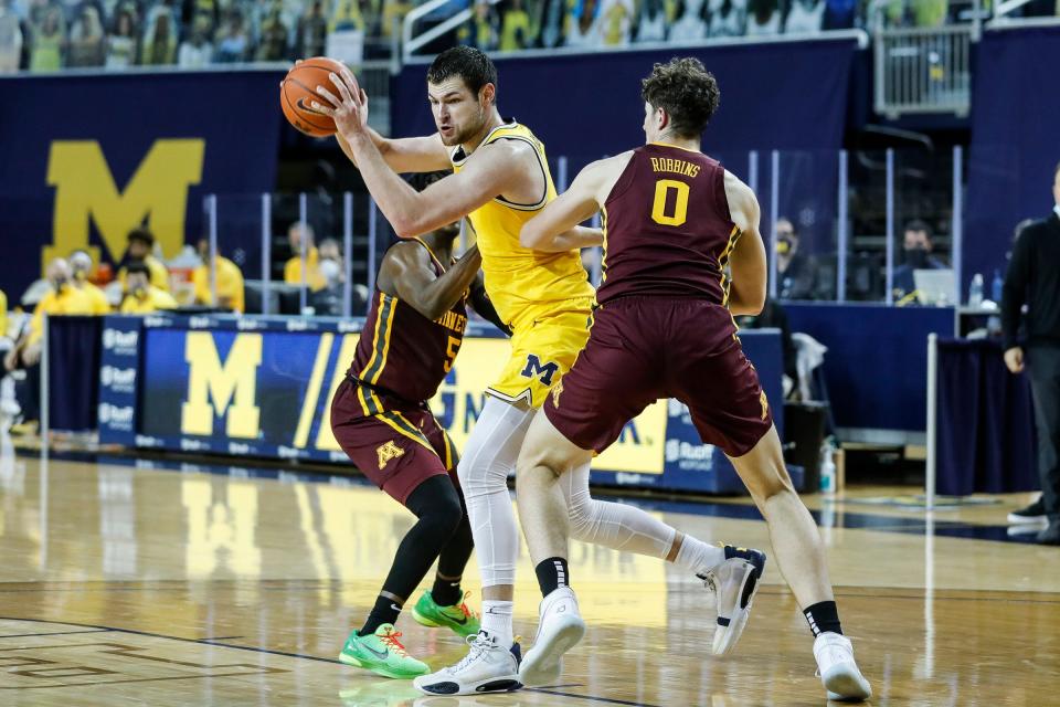 Michigan center Hunter Dickinson (1) is defended by Minnesota guard Marcus Carr (5) and center Liam Robbins (0) during the first half at the Crisler Center in Ann Arbor on Wednesday, Jan. 6, 2021.