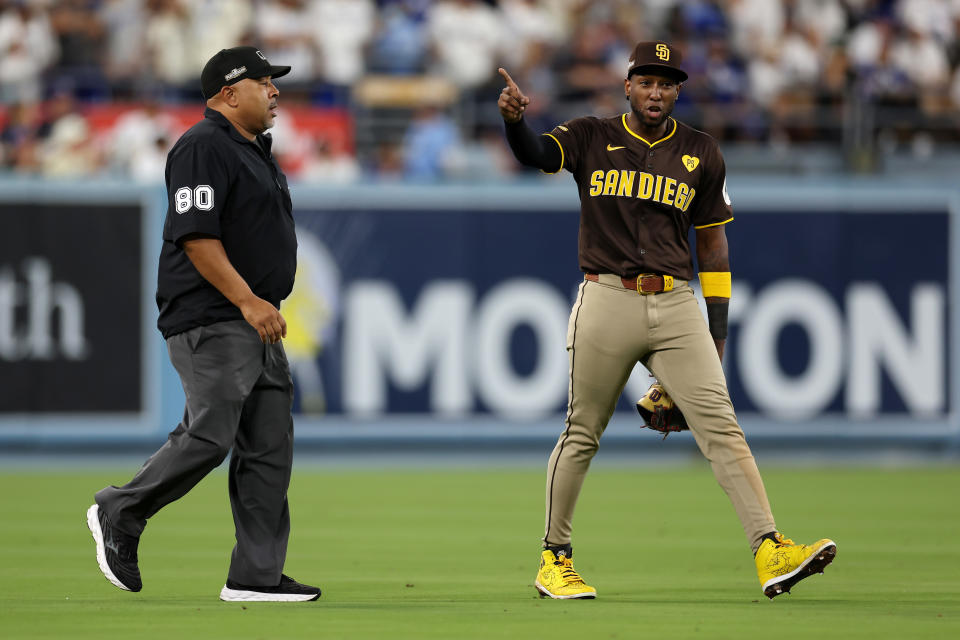 Umpires gave Jurickson Profar an escort in the outfield after Dodgers fans started throwing items on the field. (Harry How/Getty Images)