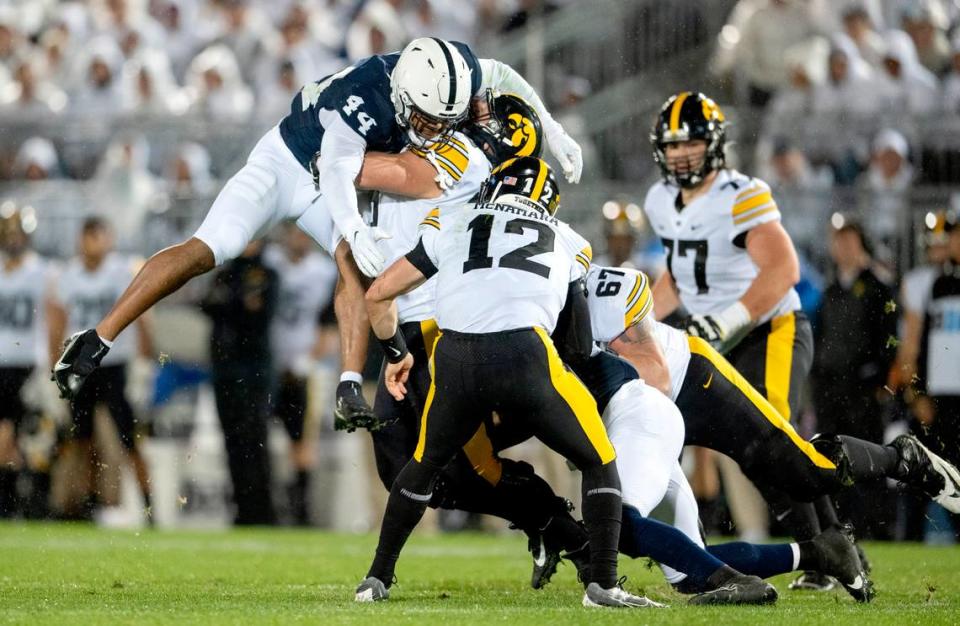 Penn State defensive end Chop Robinson leaps toward Iowa’s Cade McNamara as he is hit by Adisa Isaac during the game on Sept. 23.