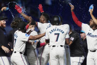 Miami Marlins' Jesús Sánchez, center, is congratulated by his teammates after his hit led to the winning run during the 10 inning a baseball game against the Colorado Rockies, Thursday, May 2, 2024, in Miami. The Marlins defeated the Rockies 5-4. (AP Photo/Marta Lavandier)