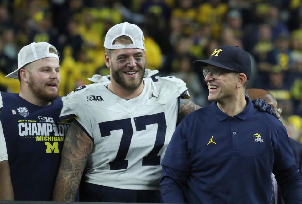 Michigan offensive lineman <a class="link " href="https://sports.yahoo.com/ncaaf/players/306533" data-i13n="sec:content-canvas;subsec:anchor_text;elm:context_link" data-ylk="slk:Trevor Keegan;sec:content-canvas;subsec:anchor_text;elm:context_link;itc:0">Trevor Keegan</a> and coach Jim Harbaugh after U-M’s 26-0 win over Iowa in the Big Ten championship game on Saturday, Dec. 2, 2023, in Indianapolis.