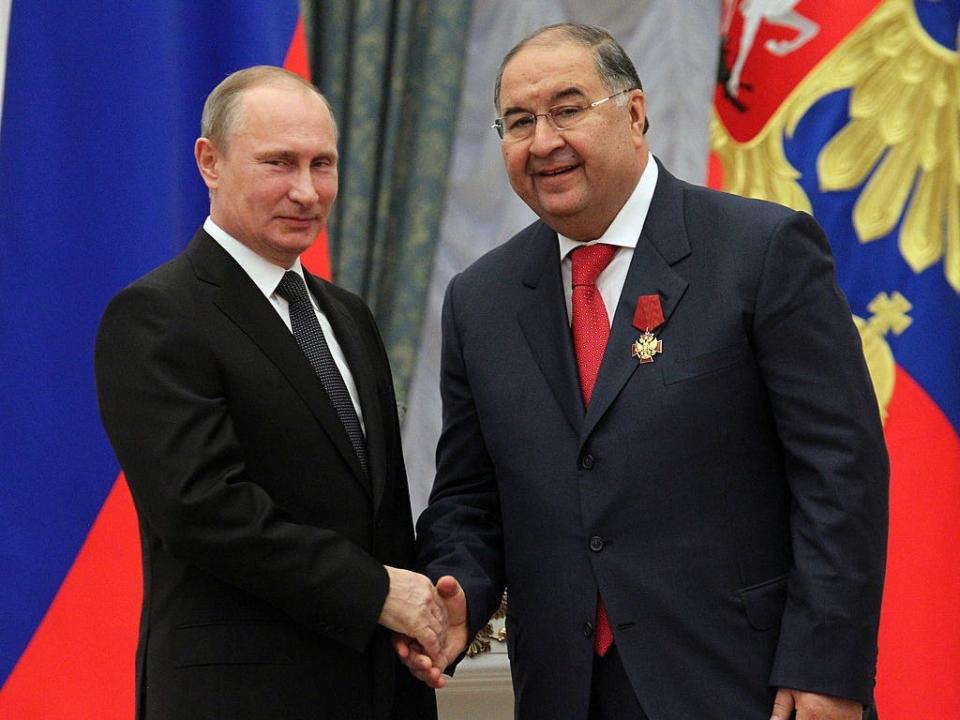 Russian President Vladimir Putin (L) shakes hands with billionaire Alisher Usmanov during an awards ceremony at the Kremlin