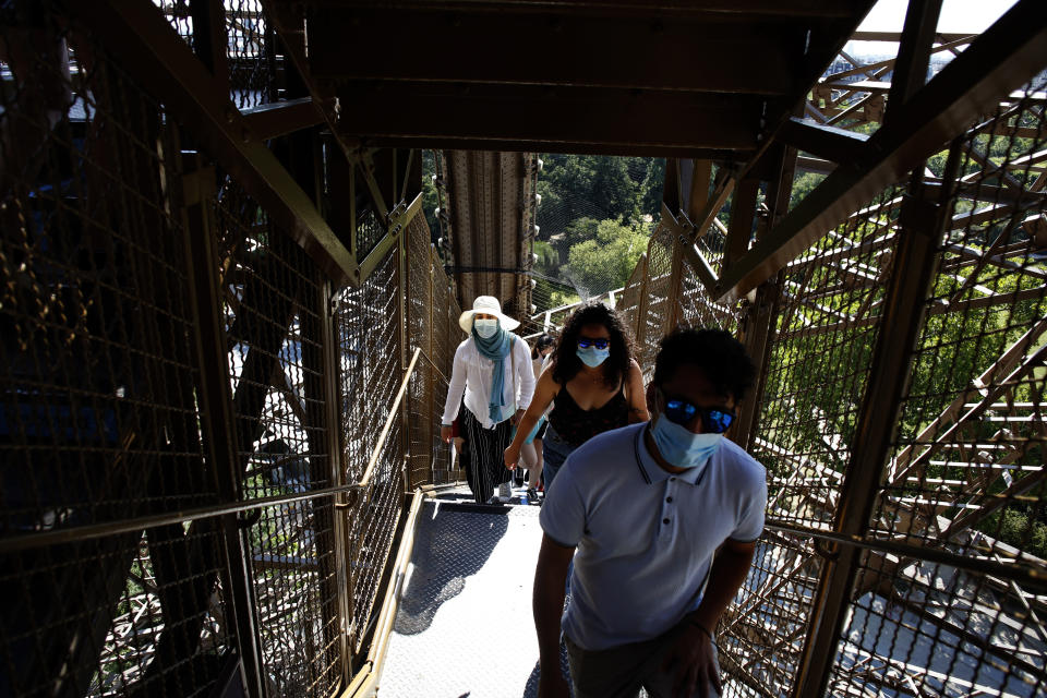 People climb stairs as they visit the Eiffel Tower, in Paris, Thursday, June 25, 2020. The Eiffel Tower reopens after the coronavirus pandemic led to the iconic Paris landmark's longest closure since World War II. (AP Photo/Thibault Camus)