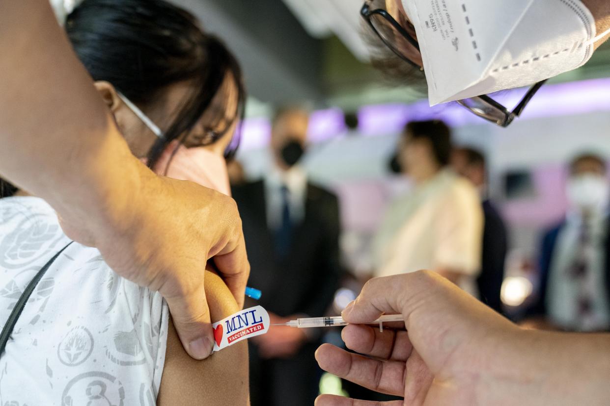 Secretary of State Antony Blinken, background left, watches as Gabrielle Cubacub, 15, gets a COVID-19 vaccination at a clinic at the Manila Zoo in Manila, Philippines, Saturday, Aug. 6, 2022. Blinken is on a ten-day trip to Cambodia, Philippines, South Africa, Congo, and Rwanda. (AP Photo/Andrew Harnik, Pool)