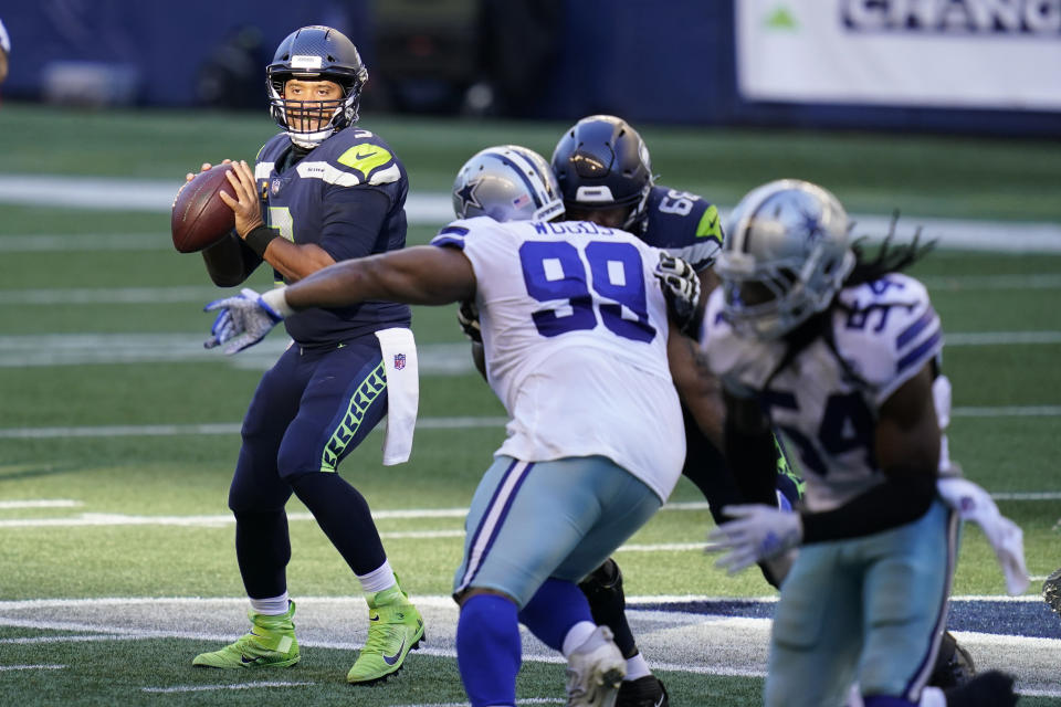 Seattle Seahawks quarterback Russell Wilson, left, looks to pass against the Dallas Cowboys during the second half of an NFL football game, Sunday, Sept. 27, 2020, in Seattle. (AP Photo/Elaine Thompson)