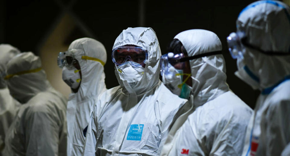 Six medical workers in full protective gear fighting coronavirus.