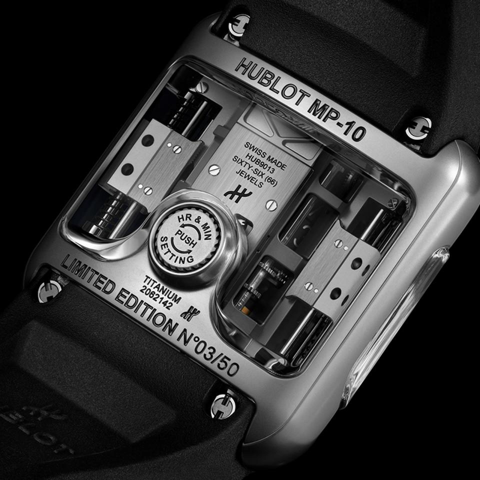 MP-10兩側的上鍊機構是錶款的一大特色，HUBLOT運用了重力原理，在中央結構的兩側放置兩個白金塊，沿著軸線可自由上下移動進行自動上鍊。另外，可調校小時和分鐘的錶冠也隱藏在錶背，要操作時按下PUSH錶冠便會凸起，操作完畢再下壓即可，完全不影響配戴。