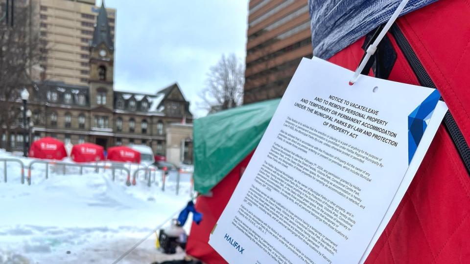 A notice from the Halifax municipality is shown attached to a tent in Grand Parade in Halifax on Wednesday, Feb. 7, 2024.