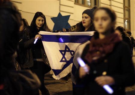 Members of the young Jewish community attend a commemoration ceremony for Holocaust victims in front of the synagogue in Vienna November 9, 2013. November 9th marks the 75th anniversary of the 'Kristallnacht' ('crystal night' or also referred to as 'night of broken glass') when Nazi thugs conducted a wave of violent anti-Jewish pogroms on the streets of Vienna and other cities in 1938 in Austria and Germany. REUTERS/Leonhard Foeger