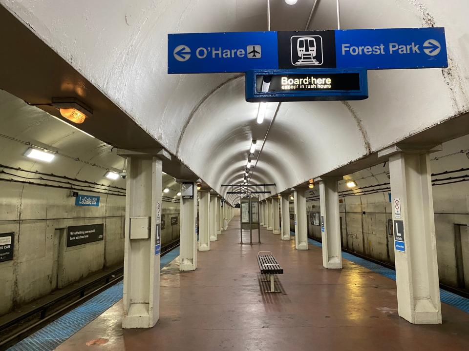 a completely empty subway station in Chicago with signs hanging above