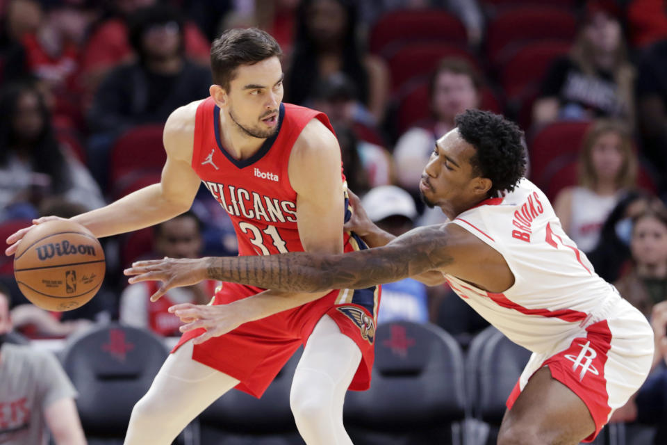 New Orleans Pelicans guard Tomas Satoransky (31) protects the ball from the reach of Houston Rockets guard Armoni Brooks, right, during the first half of an NBA basketball game, Sunday, Dec. 5, 2021, in Houston. (AP Photo/Michael Wyke)