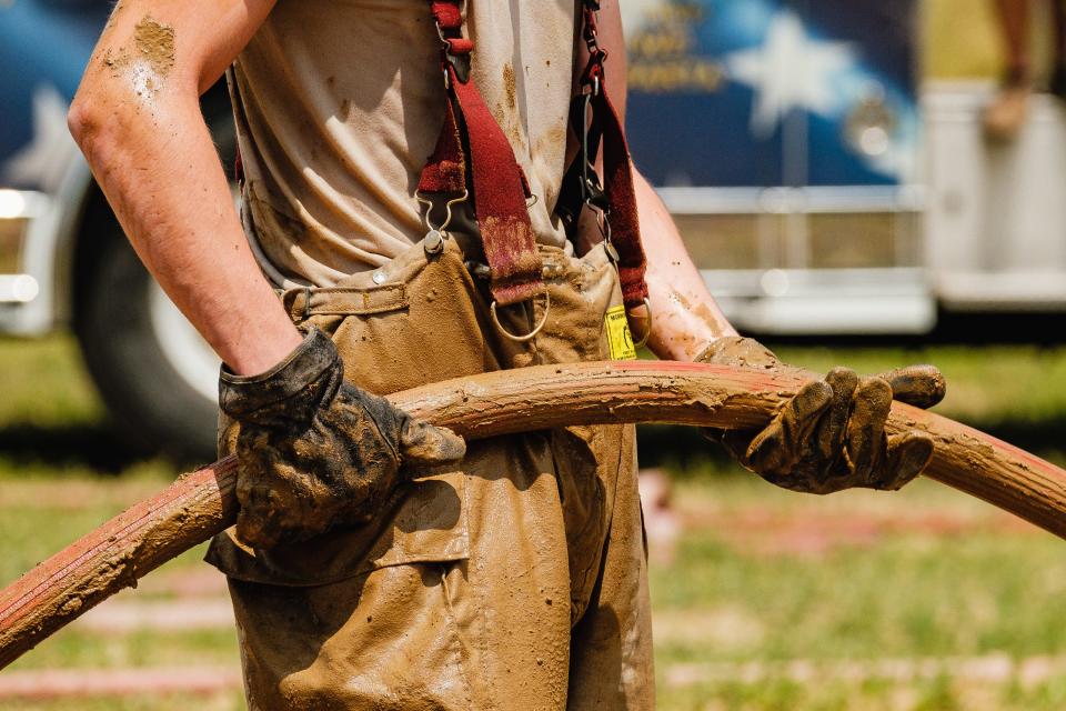 A firefighter holds a hose line during the water-barrel battle during the fourth annual HRN Firefighter Field Day, Saturday, June 10 at the Tuscarawas County Fairgrounds in Dover. Proceeds from the event went to benefit the Akron Children’s Hospital Burn Camp program.