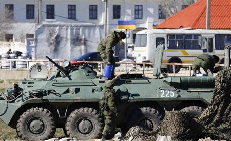 Armed men, believed to be Russian servicemen, supply an armoured personnel carrier (APC) in front of a Ukrainian marine base in the Crimean port city of Feodosia March 23, 2014. REUTERS/Shamil Zhumatov