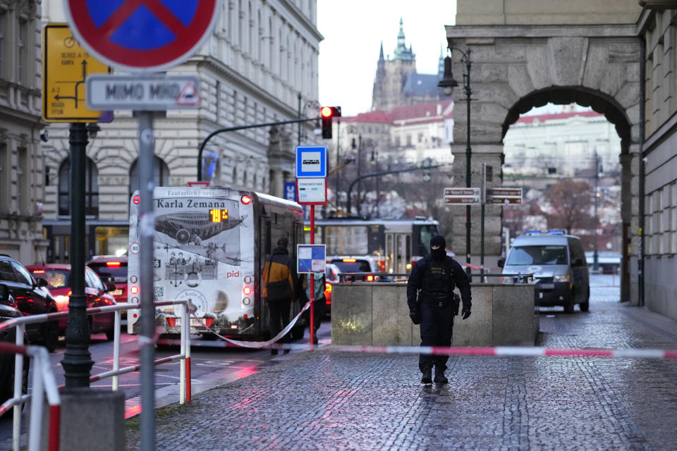 A policeman guards the area outside the building of Philosophical Faculty of Charles University Prague, Czech Republic, Friday, Dec. 22, 2023. A lone gunman opened fire at a university on Thursday, killing more than a dozen people and injuring scores of people. (AP Photo/Petr David Josek)