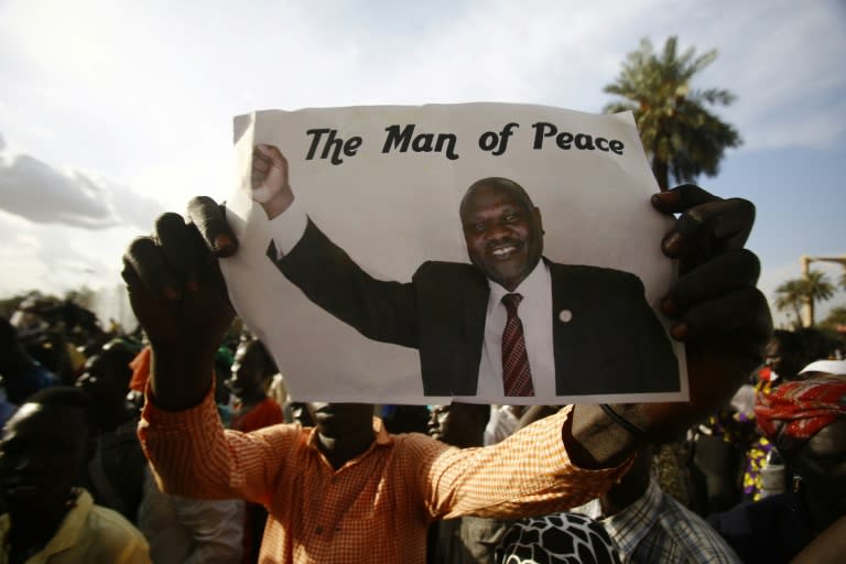 A man holds a picture of South Sudanese rebel leader Riek Machar