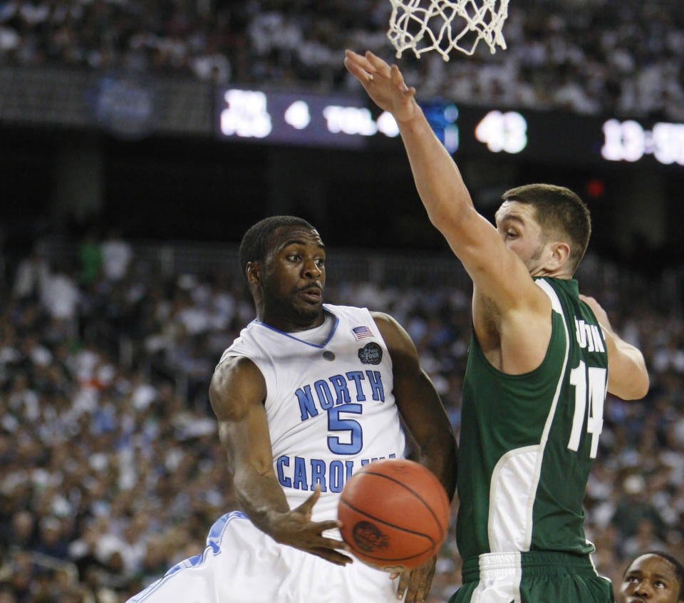 FILE - North Carolina's Ty Lawson (5) drives to the basket past Michigan State's Goran Suton, right, during their Final Four NCAA college basketball championship game in Detroit, April 6, 2009. The game ended a season that had six different No. 1-ranked teams in the AP men’s college basketball poll. (AP Photo/Carlos Osorio, File)