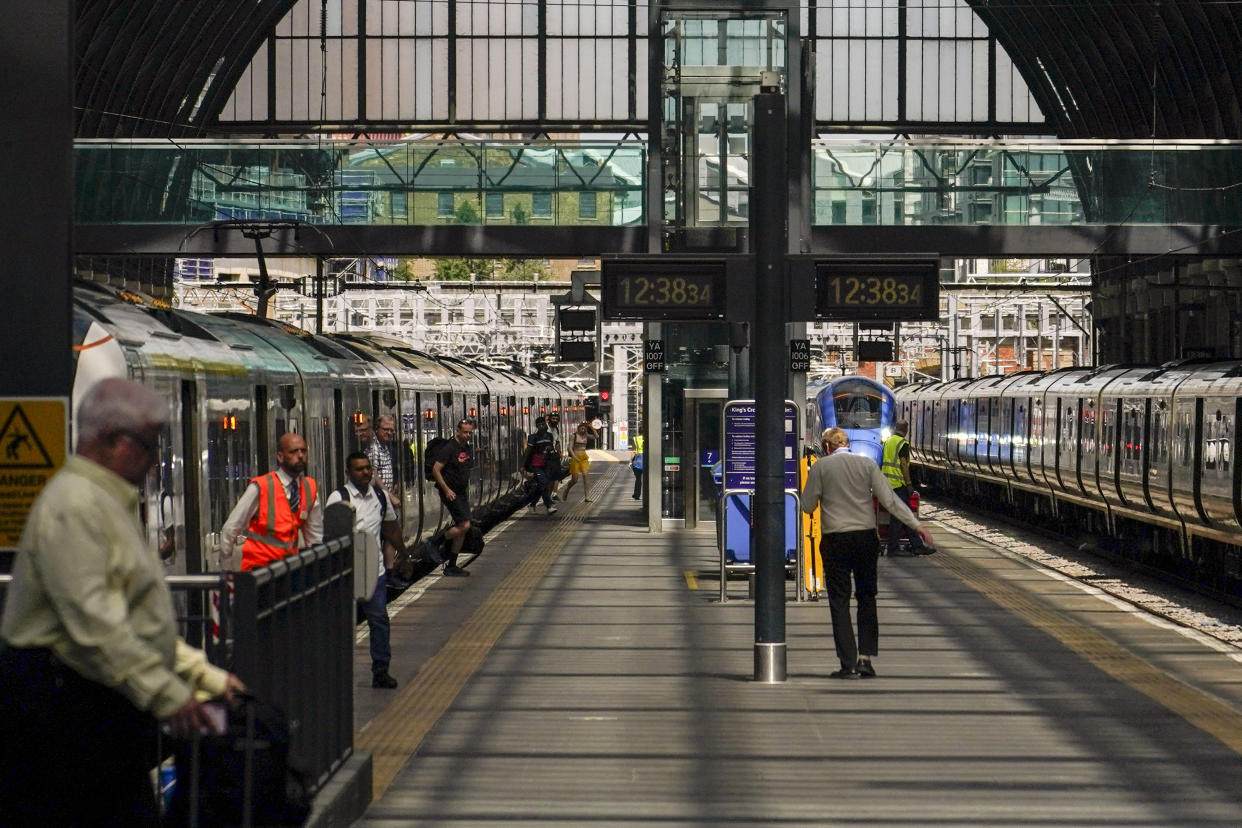 People dismount from a train at King's Cross station, in London, Tuesday, June 21, 2022. Tens of thousands of railway workers walked off the job in Britain on Tuesday, bringing the train network to a crawl in the country's biggest transit strike for three decades. (AP Photo/Alberto Pezzali)