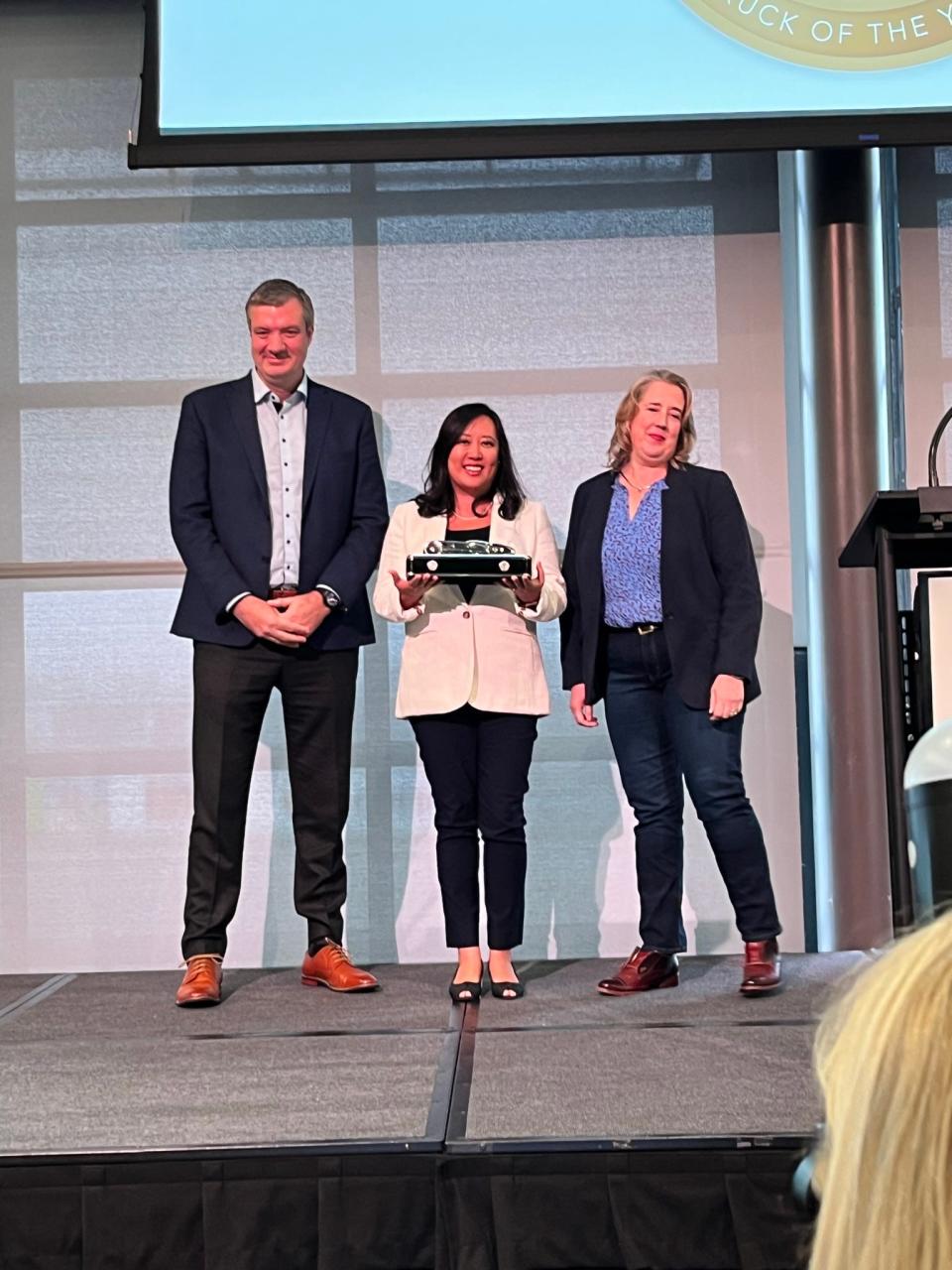 Left to right: Ford electric vehicles chief Darren Palmer and F-150 Lightning chief engineer Linda Zhang accept the 2023 North American Truck of the Year trophy from NACTOY secretary Nicole Wakelin.