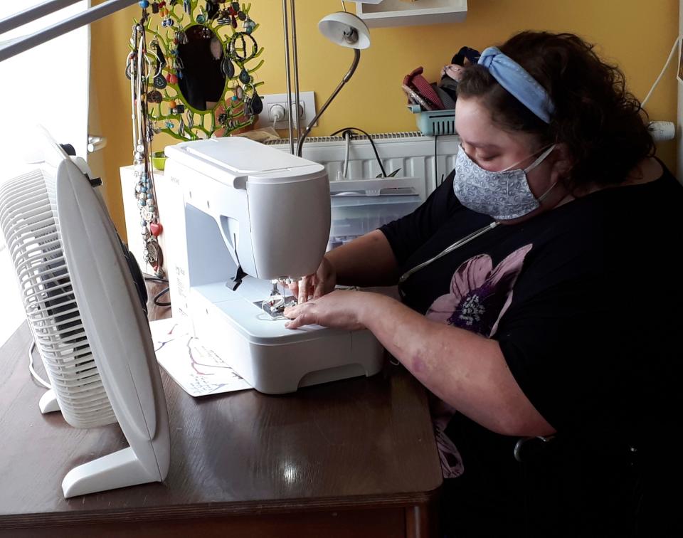 In this photo taken on Thursday, March 19, 2020, Sien Lagae, works on a mouth mask, meant to help protect from the spread of COVID-19, on her sewing machine at home in Torhout, Belgium. Lagae runs a social media group of volunteers who are making mouth masks for family and friends as well as hospital and caregivers in Belgium due to a shortage in supply of industrially made masks. For most people, the new coronavirus causes only mild or moderate symptoms, such as fever and cough. For some, especially older adults and people with existing health problems, it can cause more severe illness, including pneumonia.(Sien Lagae via AP)