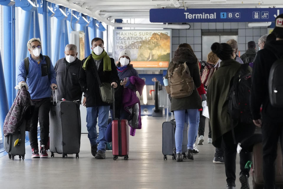 Travelers walk through Terminal 1 at O'Hare International Airport in Chicago, Thursday, Dec. 30, 2021. (AP Photo/Nam Y. Huh)