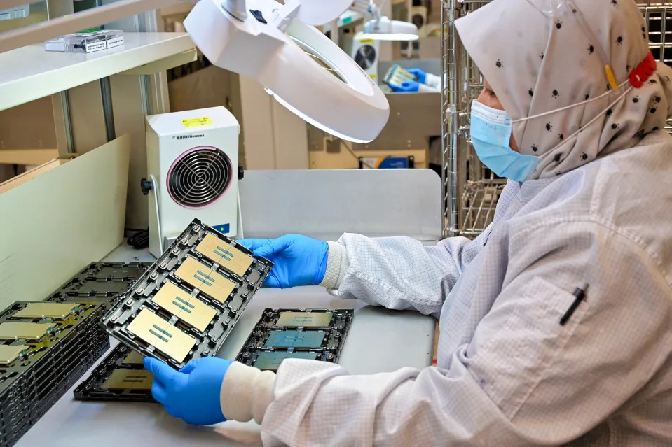 An inspector in the Kulim Assembly Test Manufacturing factory in Kulim, Malaysia, works with trays of 5th Gen Intel Xeon processors before shipment. (Credit: Intel Corporation)